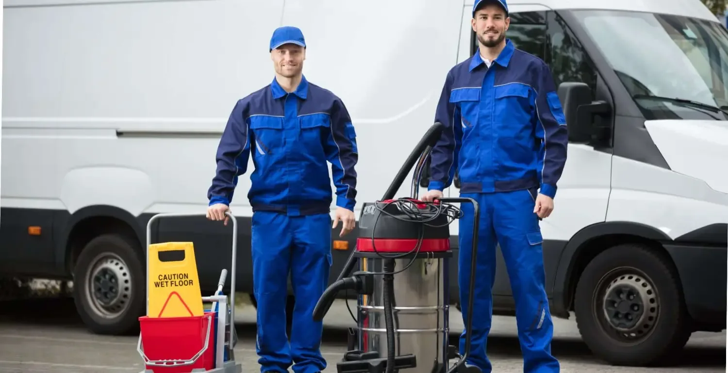 Servicekräfte in Arbeitskleidung mit Reinigungsausrüstung neben einem Transporter