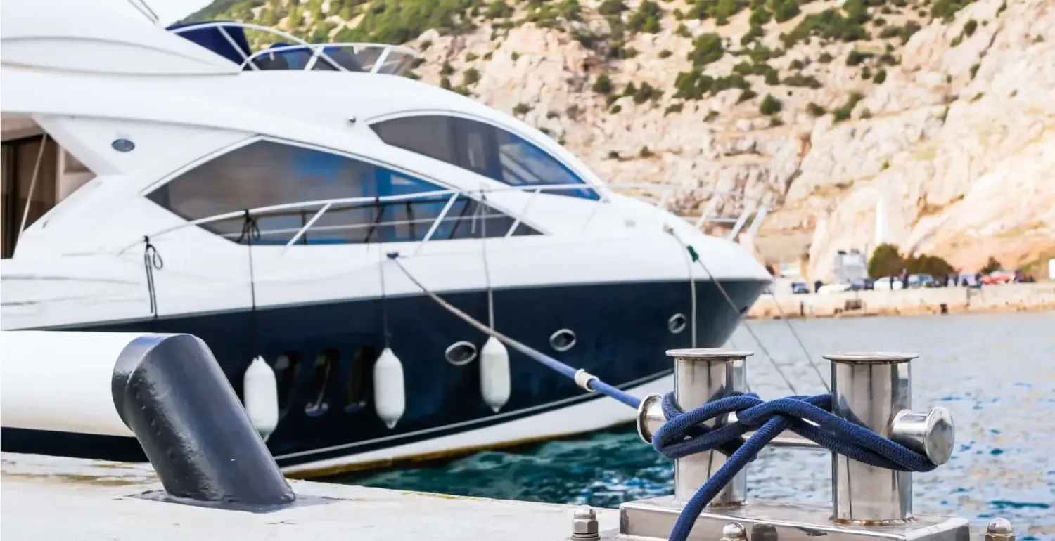 Weiße Motoryacht mit gepflegtem Rumpf an einem Steg im Hafen